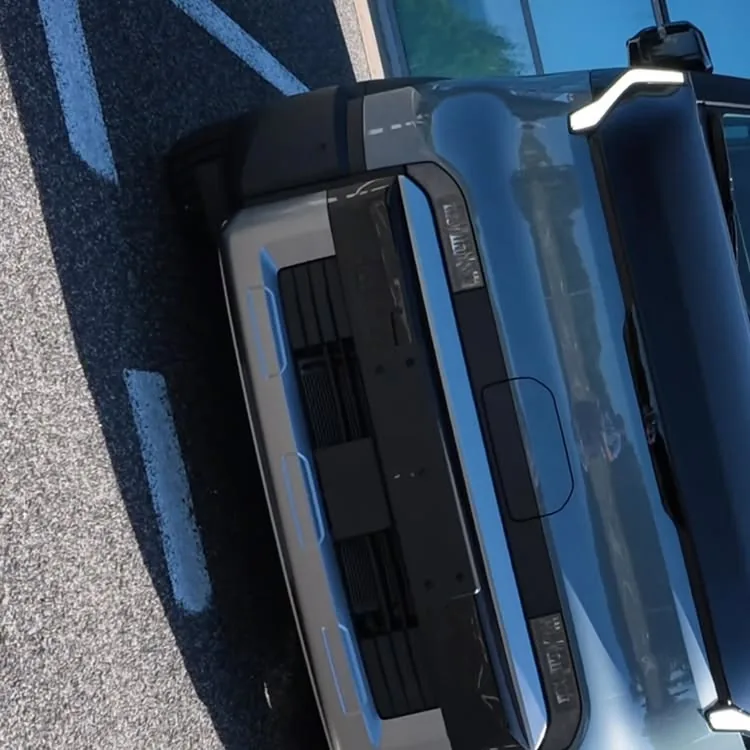 Close-up from above of the van’s front end and glossy dark bonnet, parked in a car park.